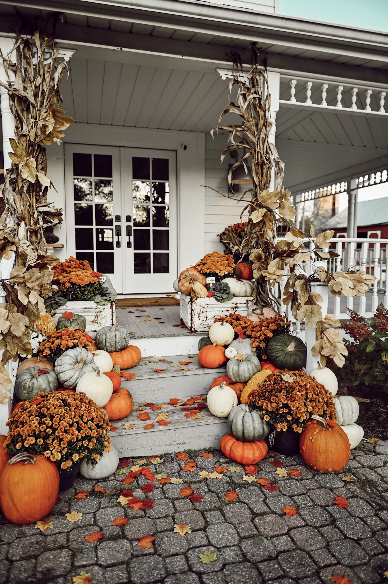Rustic farmhouse steps with cornstalks and pumpkins